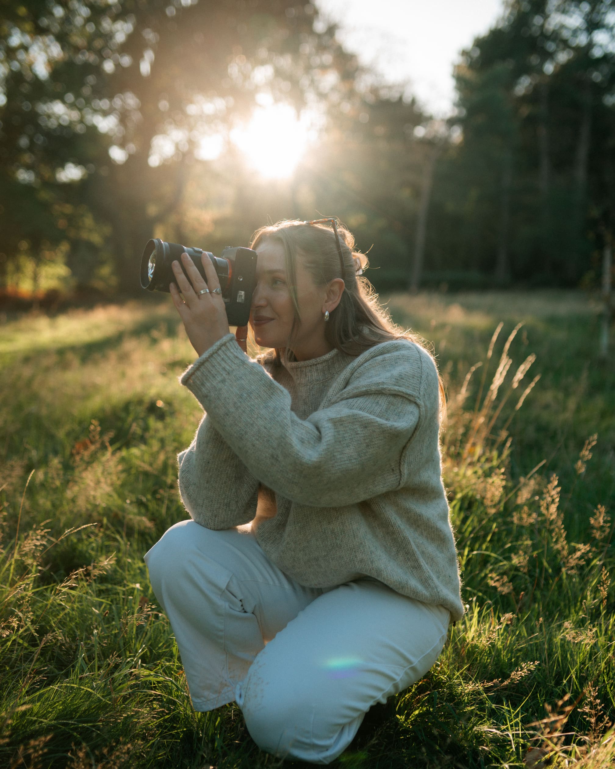 Lily photographing a mountain lake at sunrise, the peaks reflected in still water